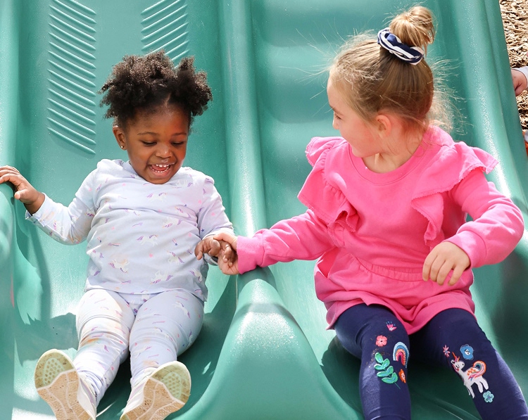 CHDS - about-main girls playing on a slide, laughing