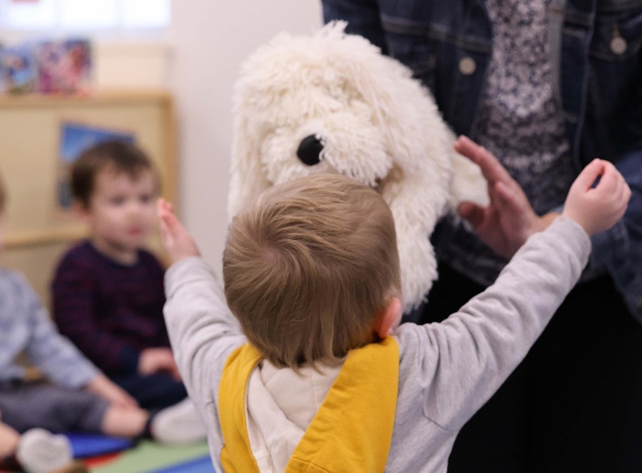 Toddler and Preschool 1 class student hugging a puppet
